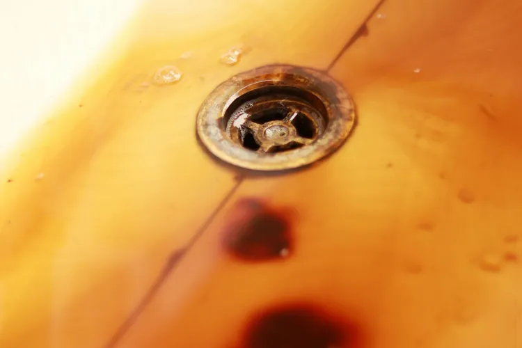 Orange rust stains around a bathtub drain
